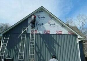 Robinson Employees replacing siding on a building in Walkertown NC